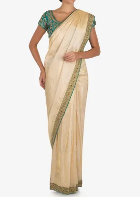 Cream saree with dark green blouse